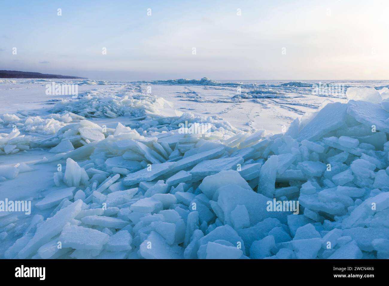 Photo de paysage avec des bosses de glace et de la neige sur une surface gelée de la mer Baltique par une journée ensoleillée d'hiver Banque D'Images