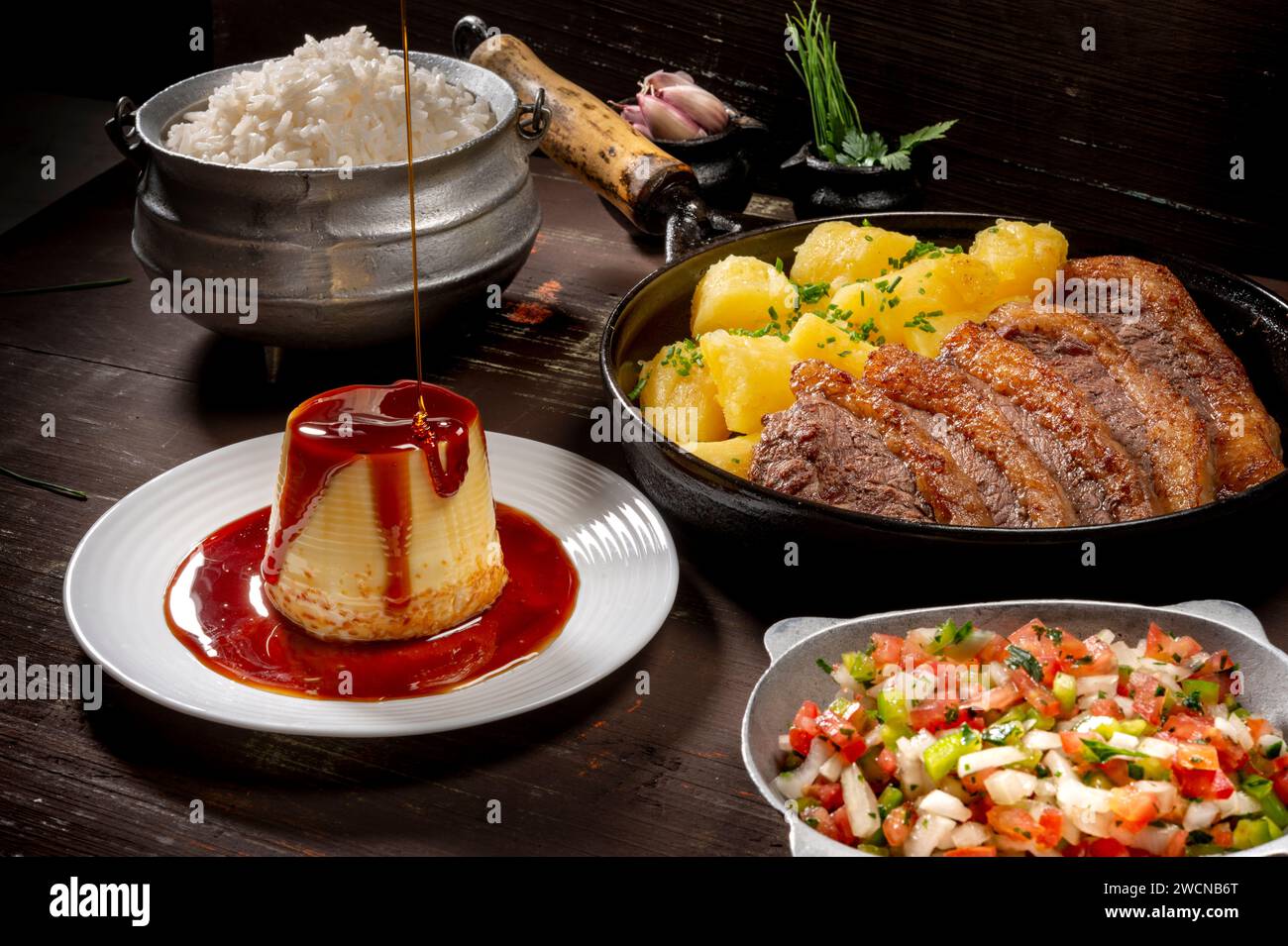 steak croustillant avec manioc frit, pudding et sauce sur table en bois, cuisine brésilienne typique Banque D'Images