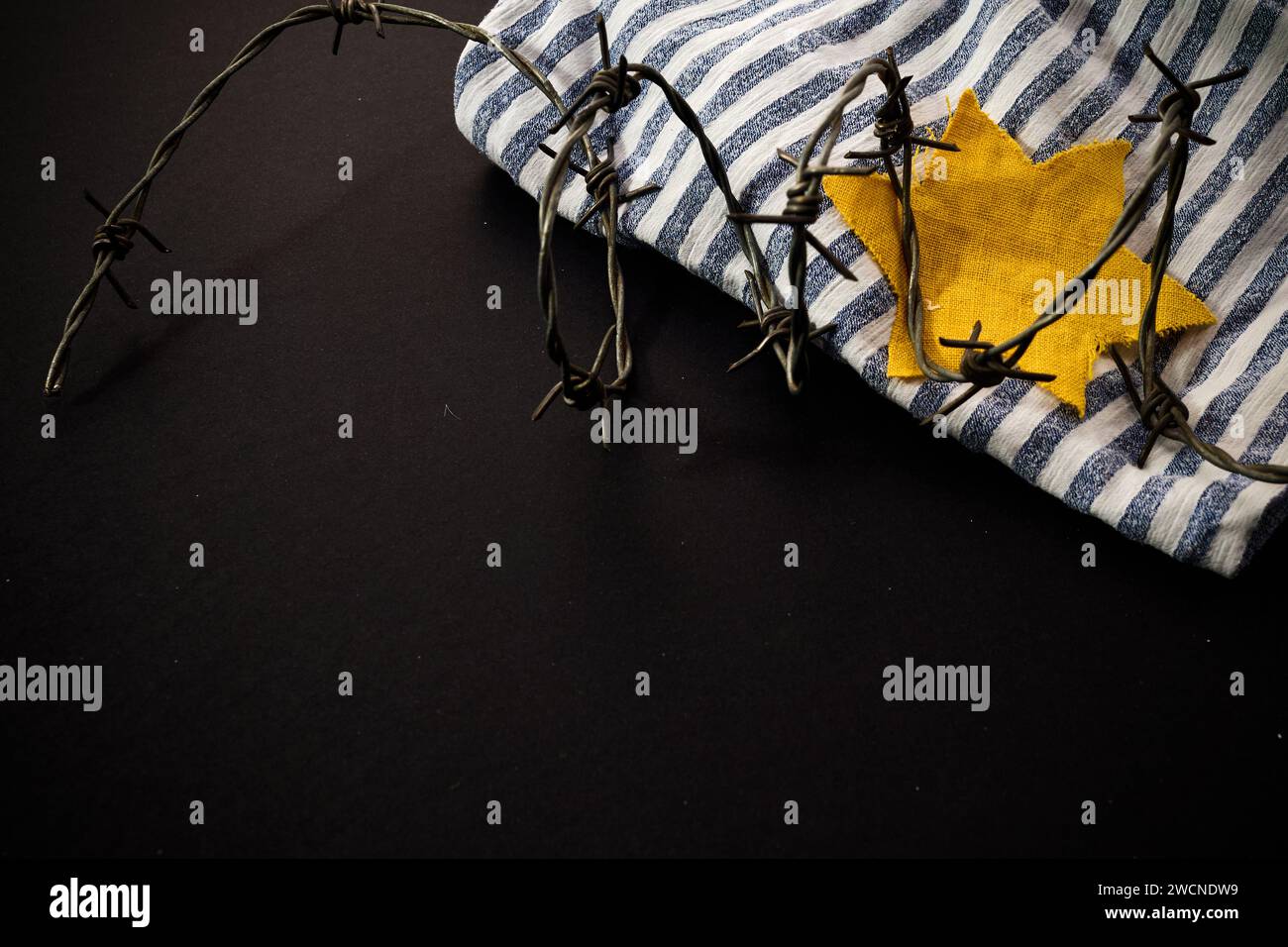 Prisonnier juif avec badge jaune sur fond sombre. Journée internationale de commémoration de l'Holocauste Banque D'Images