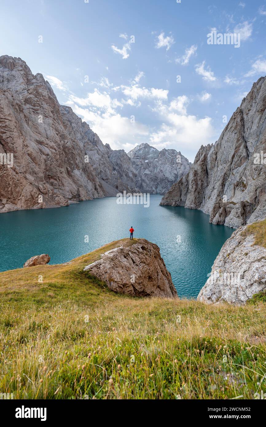 Touriste au lac de montagne bleu entre les pics rocheux escarpés de montagne, lac Kol Suu, montagnes Sary Beles, province de Naryn, Kirghizistan Banque D'Images