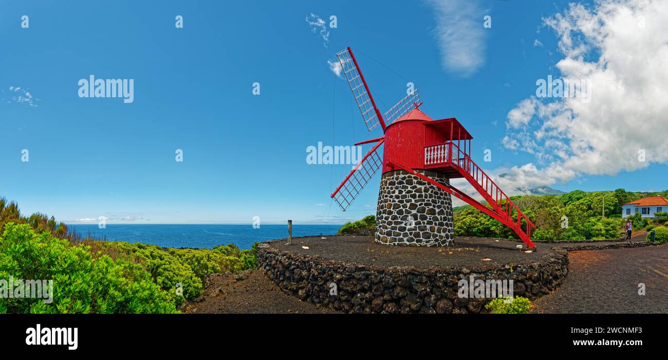 Moulin à vent peint en rouge sur pierre volcanique noire Moinho de Sao Joao sous un ciel large, Sao Joao, île de Pico, Açores, Portugal Banque D'Images