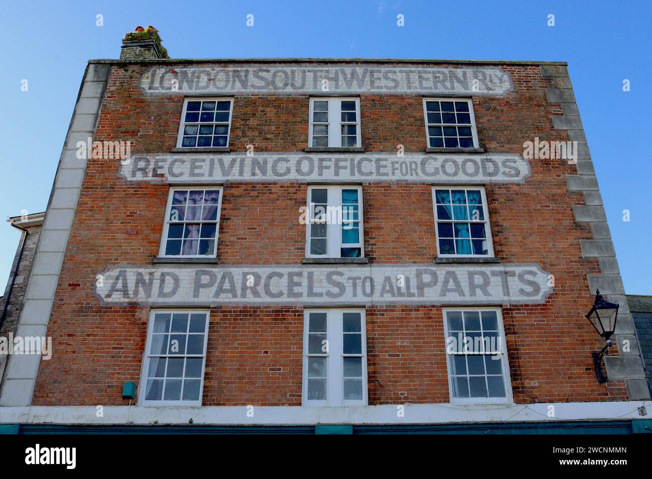 Calligraphie victorienne peinte sur la façade en briques des anciens bureaux de London & South Western Railway sur le front de mer de Barbican, Plymouth, Devon. Banque D'Images
