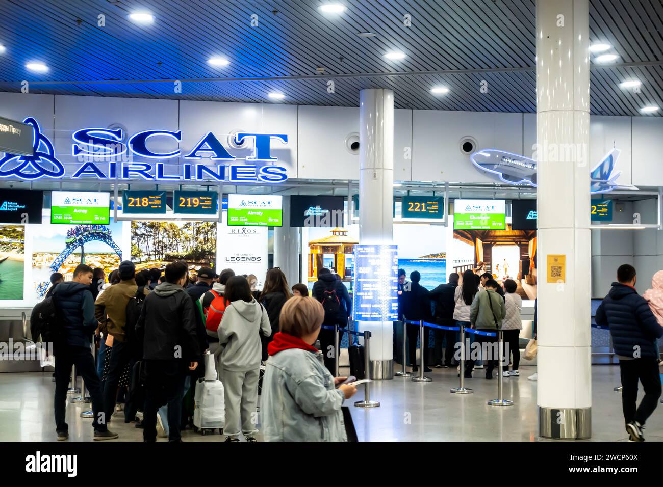 Passagers voyageurs en attente en ligne pour l'enregistrement d'un vol intérieur de Scat Airlines Kazakh transporteur aérien à Astana aéroport Kazakhstan Banque D'Images