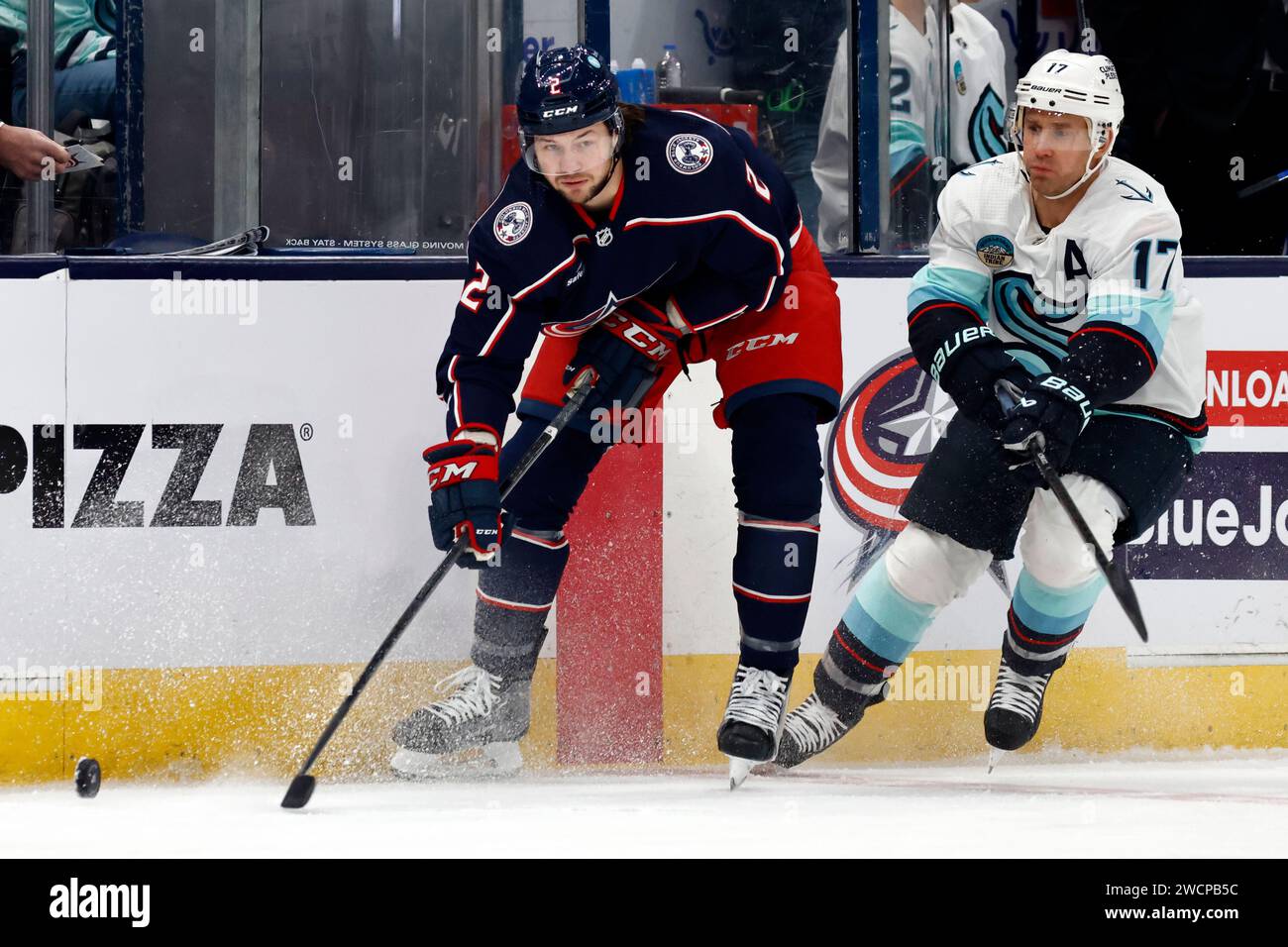 Columbus Blue Jackets defenseman Andrew Peeke, left, passes the puck in front of Seattle Kraken forward Jaden Schwartz during an NHL hockey game in Columbus, Ohio, Saturday, Jan. 13, 2024. The Kraken won 7-4. (AP Photo/Paul Vernon) Banque D'Images
