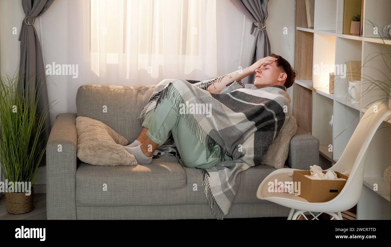 Maladie fièvre homme couverture maux de tête médicaments à la maison Banque D'Images