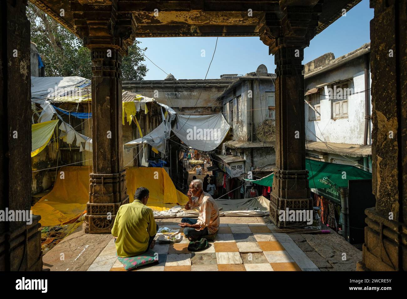 Ahmedabad, Inde - 11 janvier 2024 : deux hommes mangent près des tombes des reines d'Ahmed Shah à Ahmedabad, en Inde. Banque D'Images