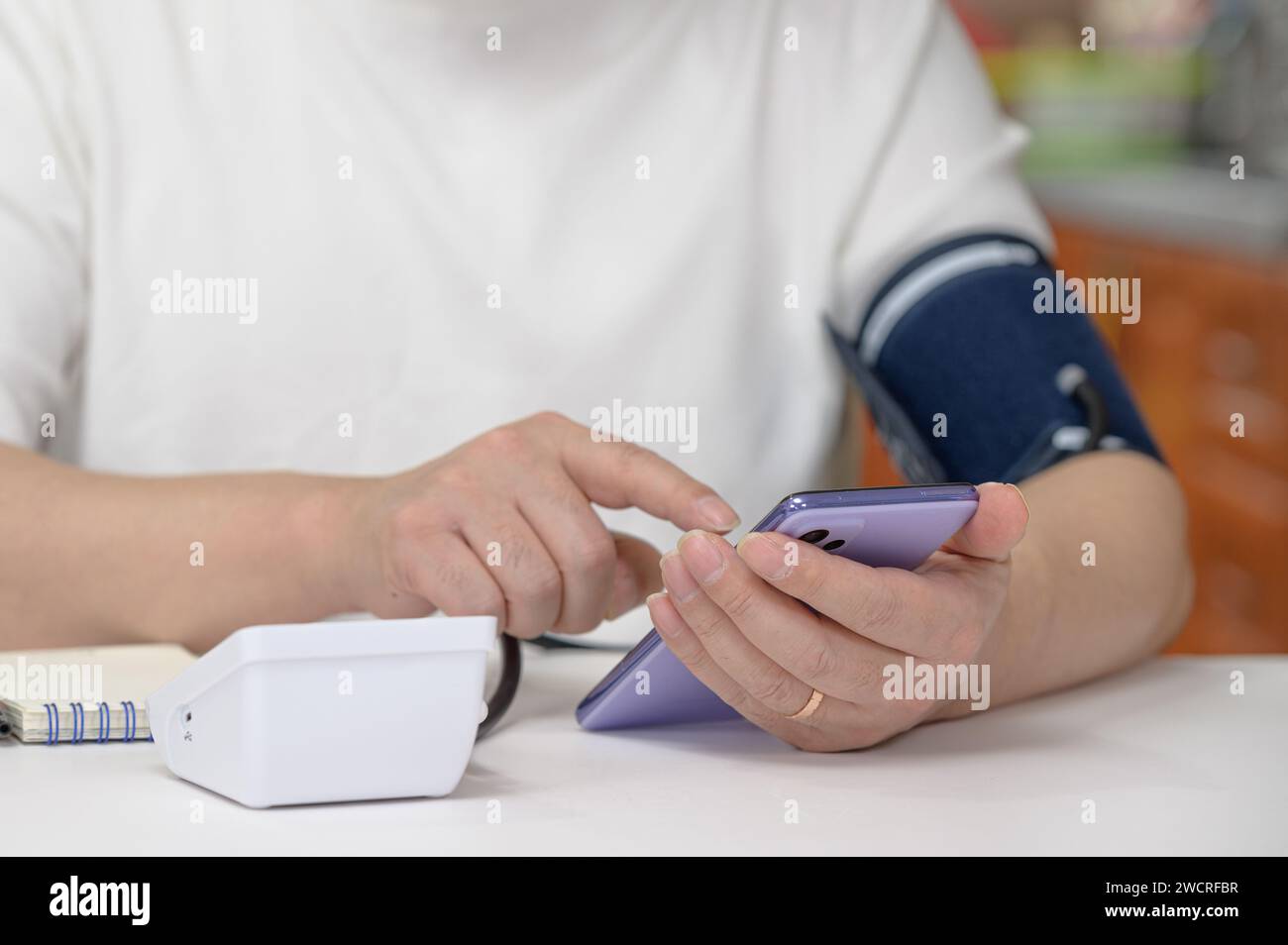 Homme d'âge moyen entrant la pression artérielle sur son smartphone. Concept de santé numérique Banque D'Images