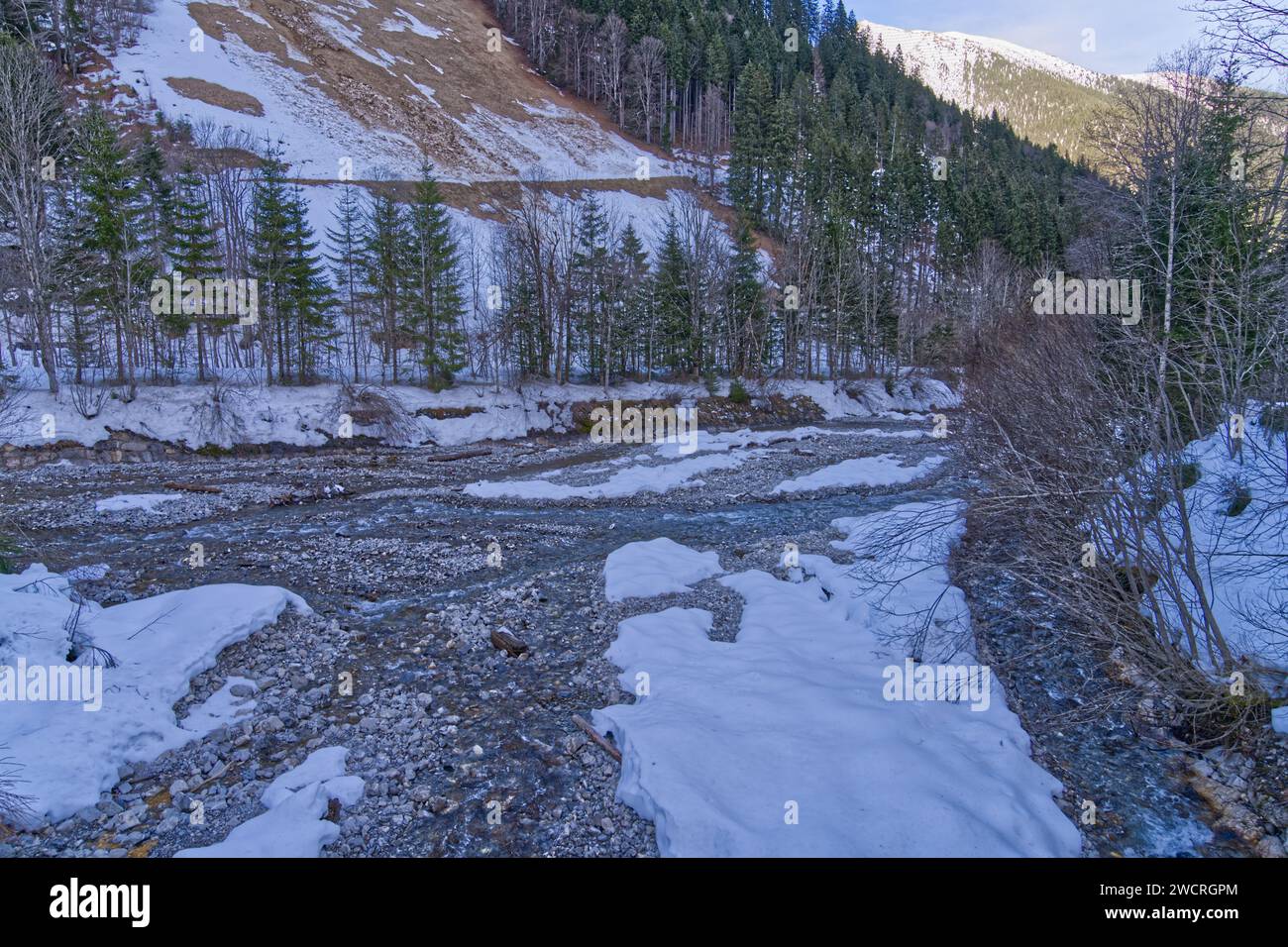 Une rivière pittoresque avec une eau cristalline qui coule doucement sur des rochers lisses, en hiver Banque D'Images