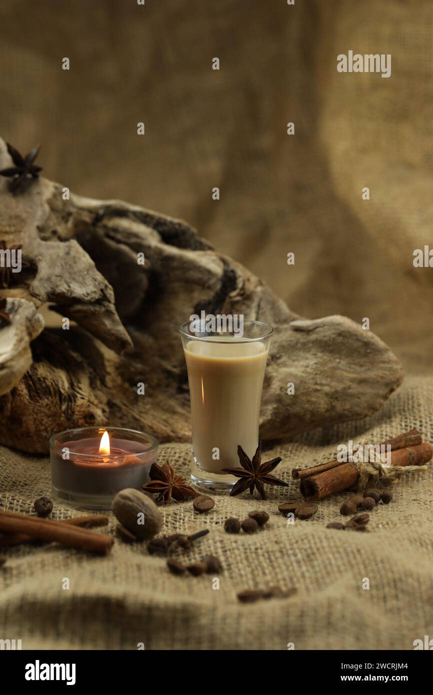 Verre de liqueur à la crème irlandaise avec épice. Fond de tissu avec espace de copie Banque D'Images