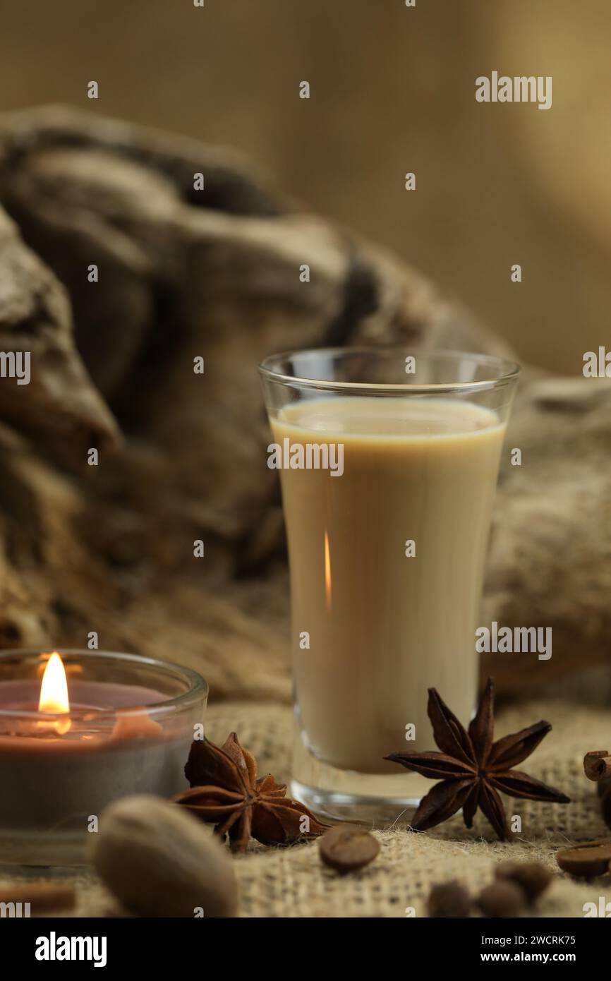Verre de liqueur à la crème irlandaise avec épice. Fond de tissu avec espace de copie Banque D'Images