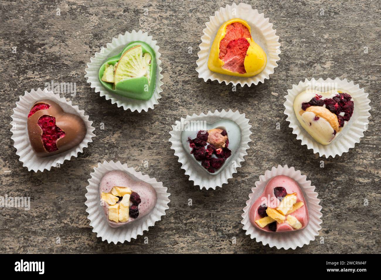 bonbons au chocolat sous forme de coeur avec fruits et noix sur fond coloré. vue de dessus avec espace pour le texte, concept de vacances. Banque D'Images