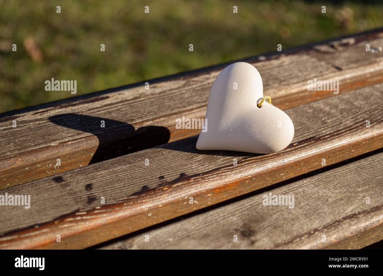 Un coeur en pierre repose sur un banc en bois Banque D'Images