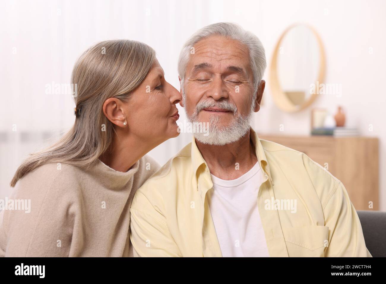 Femme aînée embrassant son homme bien-aimé à la maison Banque D'Images