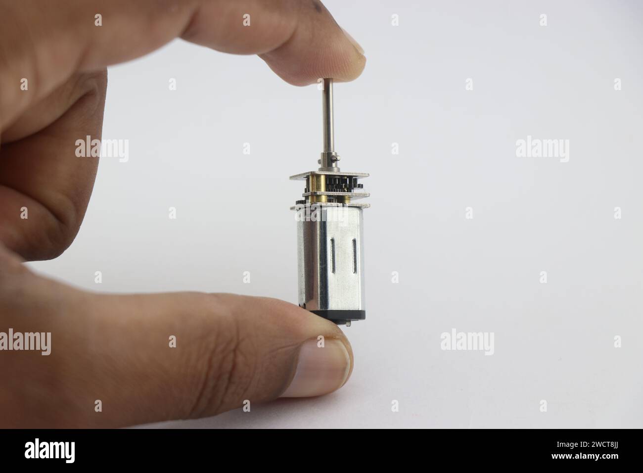 Micro moteur à engrenages en métal ou petit moteur à courant continu à engrenages tenu dans la main Banque D'Images
