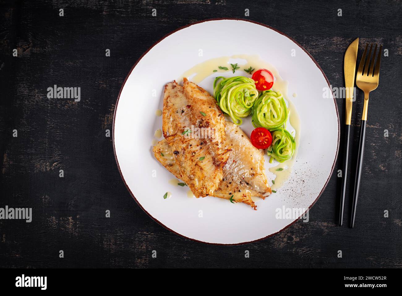 Filet de poisson grillé avec pâtes aux courgettes. Concept de nourriture saine. Vue de dessus, pose à plat Banque D'Images