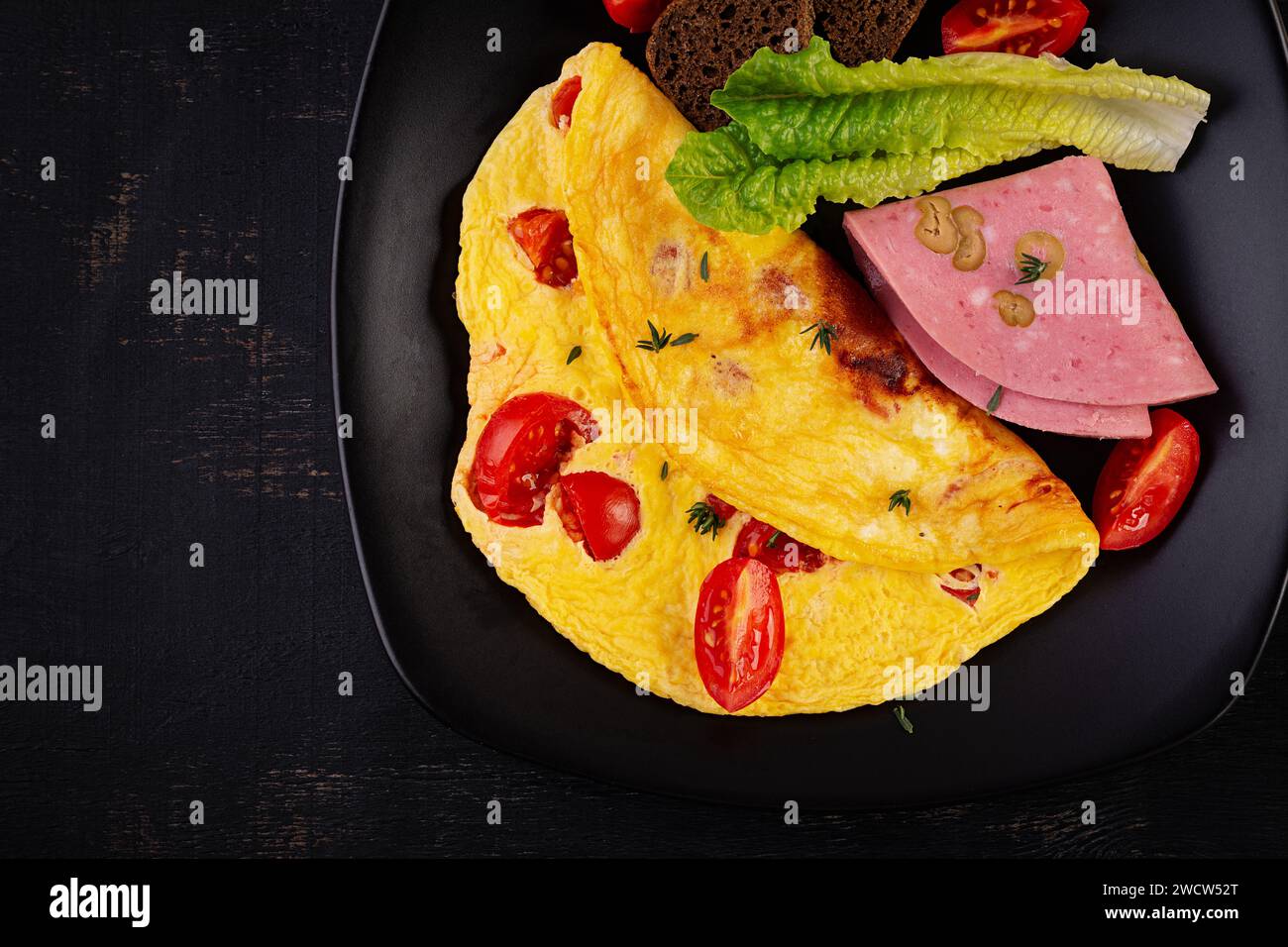Omelette aux tomates et fromage avec pain et saucisse de mortadelle. Vue de dessus Banque D'Images