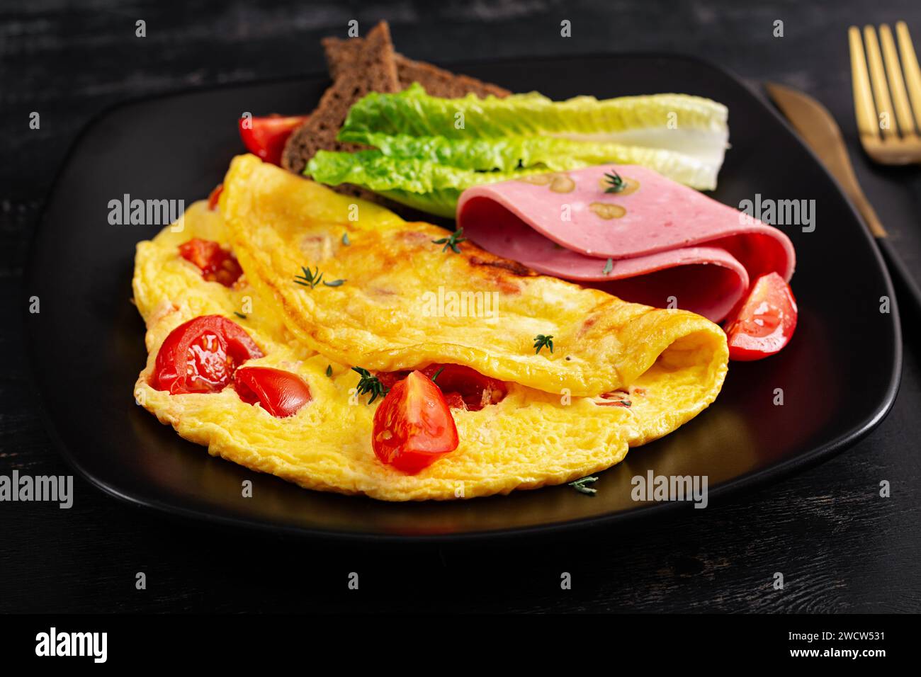 Omelette aux tomates et fromage avec pain et saucisse de mortadelle. Banque D'Images