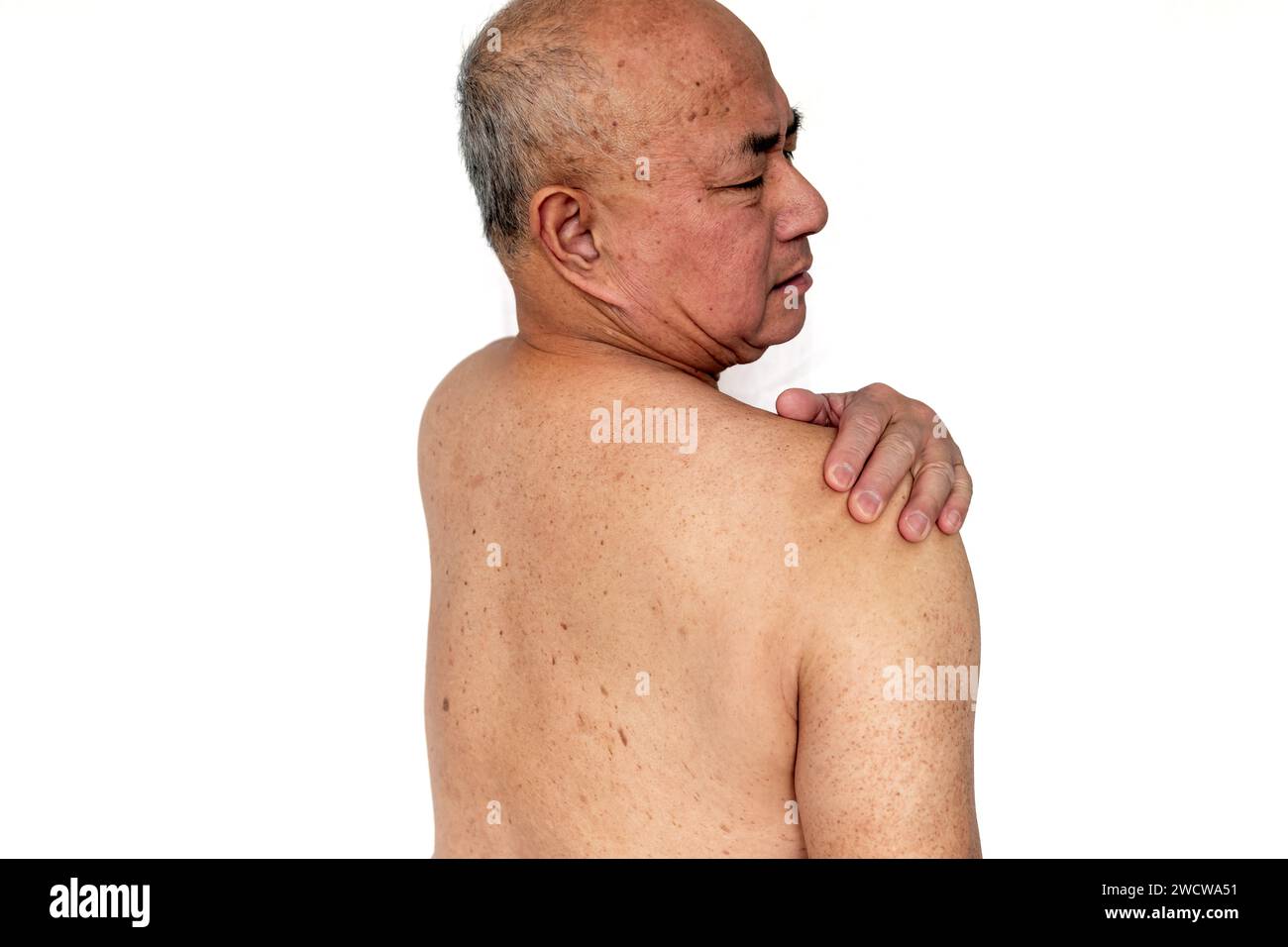 Un homme âgé avec une expression douloureuse souffrant de douleur dans l'épaule isolé dans un fond blanc Banque D'Images