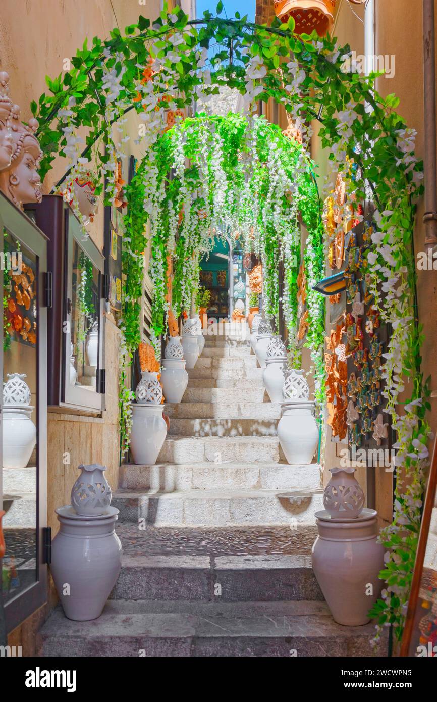 Italie, Sicile, Taormine, rue étroite dans la vieille ville remplie de pots en céramique et de décorations Banque D'Images