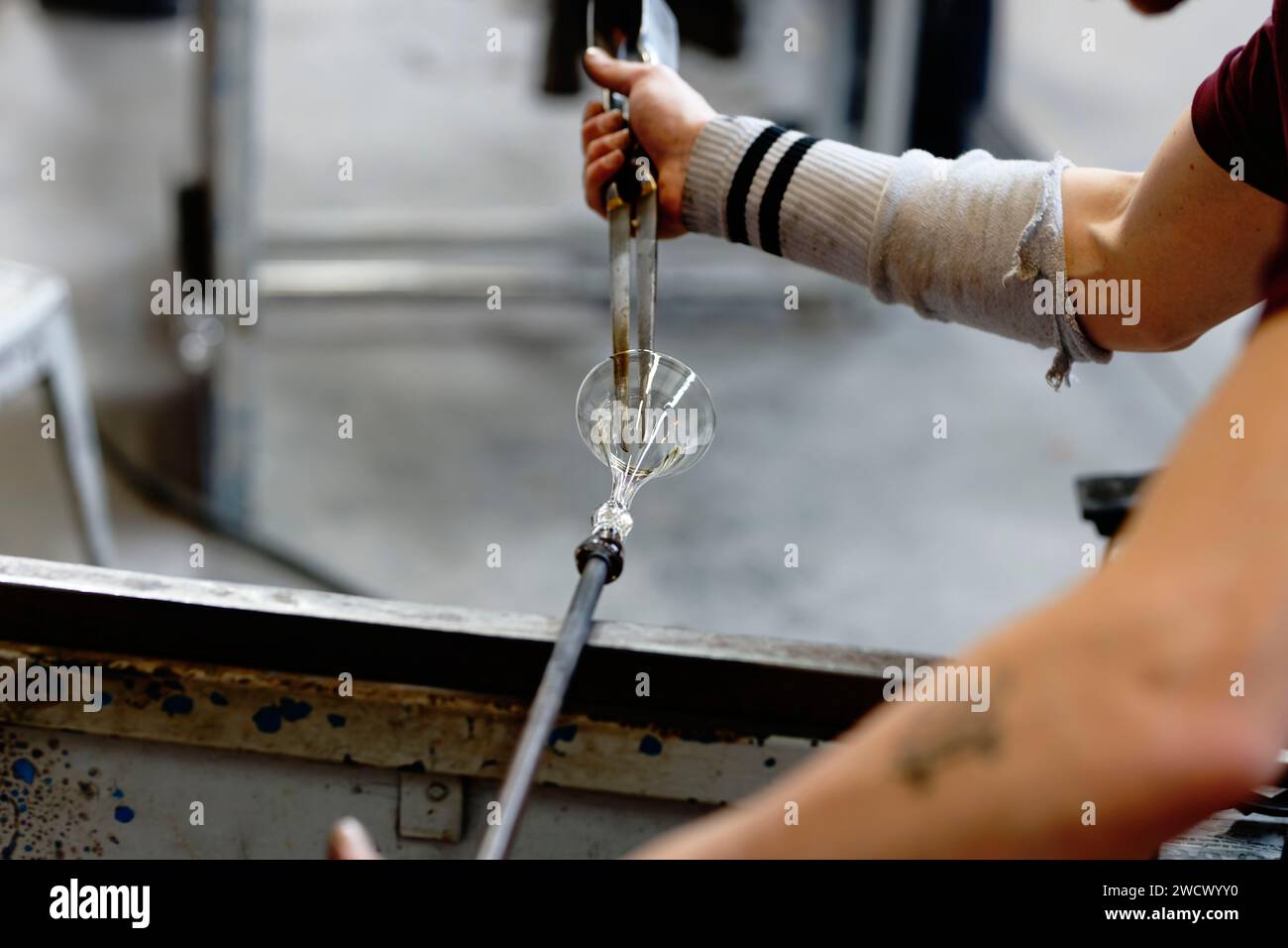 France, Meurthe et Moselle, vannes le Chatel, le Centre européen de recherche et de formation en Arts du verre (CERFAV), le seul centre français proposant toutes les spécialités du verre au même endroit, les « gestes verriers sont inscrits au patrimoine mondial de l’UNESCO, apprentis travaillant et coupant le verre après soufflage de la canne Banque D'Images