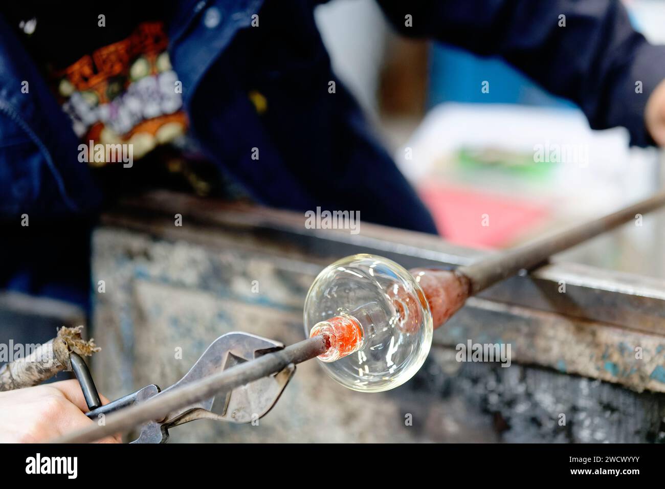 France, Meurthe et Moselle, vannes le Chatel, le Centre européen de recherche et de formation en Arts du verre (CERFAV), le seul centre français proposant toutes les spécialités du verre au même endroit, les « gestes verriers sont inscrits au patrimoine mondial de l’UNESCO, apprentis travaillant et coupant le verre après soufflage de la canne Banque D'Images