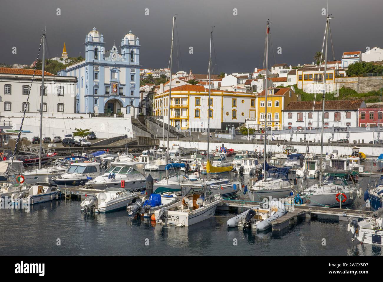 Portugal, archipel des Açores, île de Terceira, Angra do Heroismo, port accueillant des bateaux de plaisance avec l'église de la Miséricorde peinte en bleu azur et des bâtiments coloniaux colorés Banque D'Images
