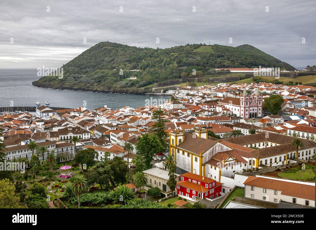 Portugal, archipel des Açores, île de Terceira, Angra do Heroismo, vue plongeante sur le centre historique et ses bâtiments blancs aux toits de tuiles avec Monte Brasil abritant le port Banque D'Images