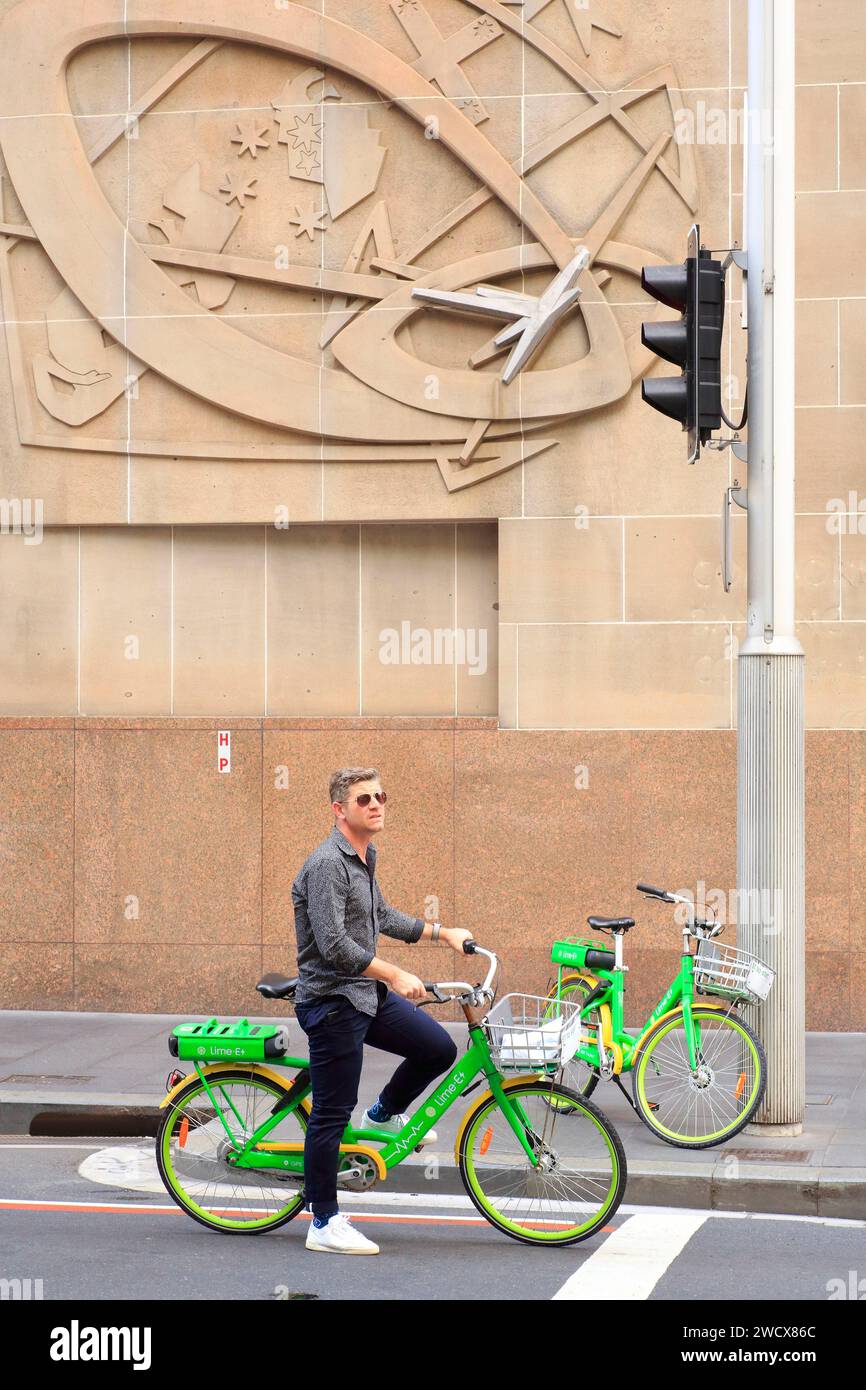 Australie, Nouvelle-Galles du Sud, Sydney, Central Business District (CBD), York Street, cycliste avec un vélo partagé à un feu de circulation Banque D'Images