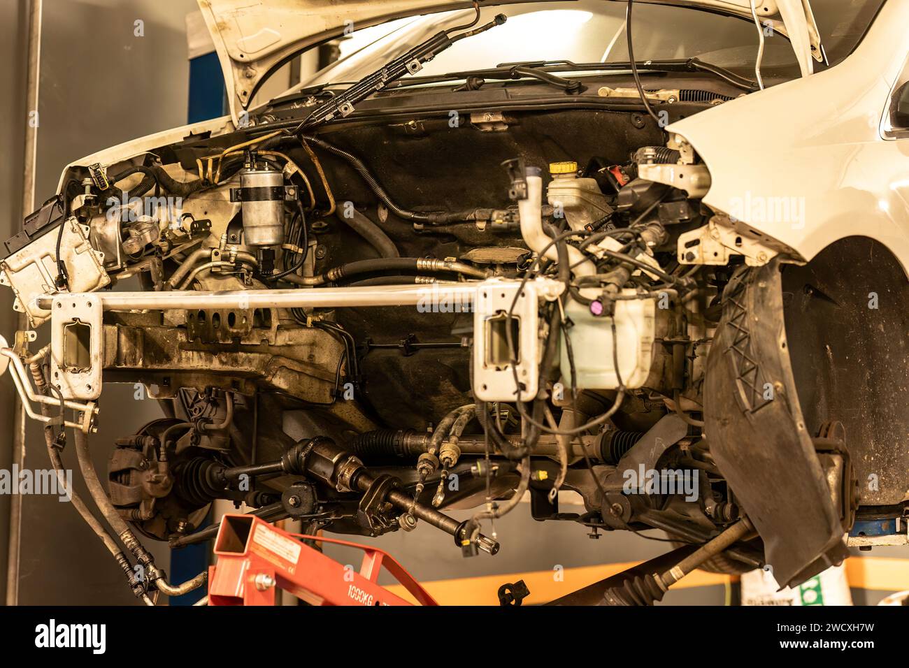 Photo d'une voiture dans un atelier manquant son moteur, en attente de réparation, montrant l'entretien automobile. Banque D'Images