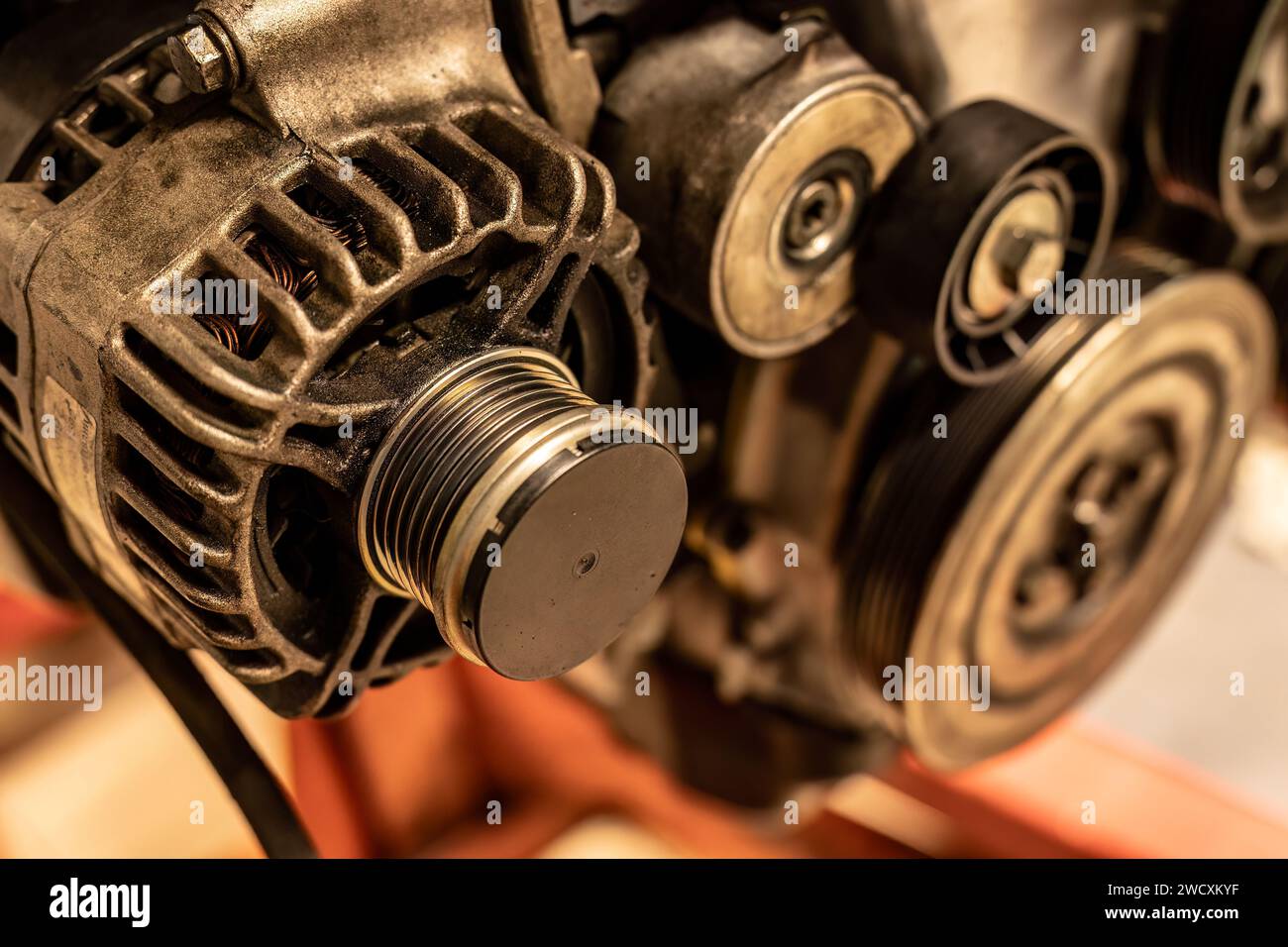 Image détaillée d'une poulie d'alternateur attachée à un moteur de voiture, montrant des pièces mécaniques complexes. Banque D'Images