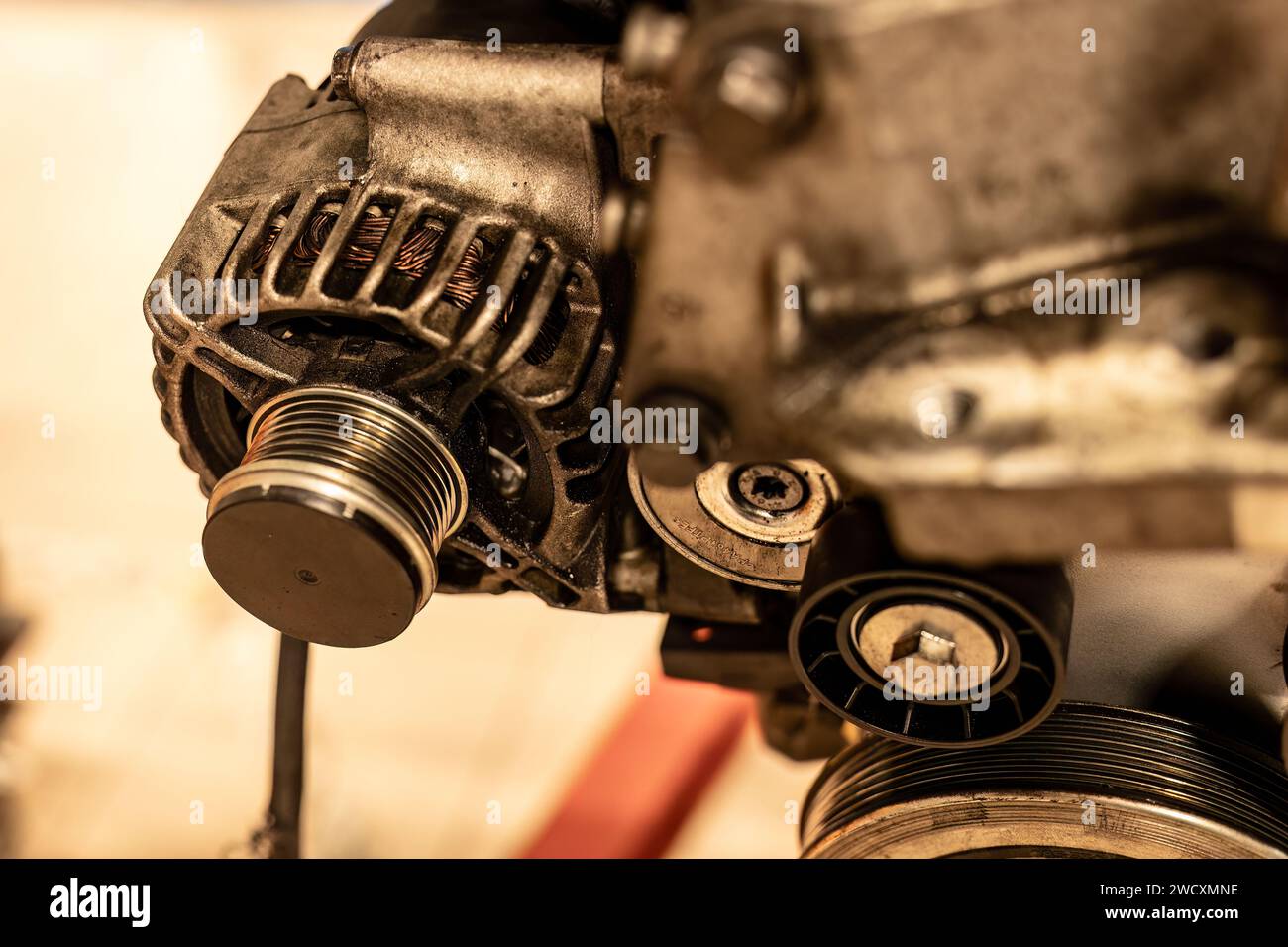 Image détaillée d'une poulie d'alternateur attachée à un moteur de voiture, montrant des pièces mécaniques complexes. Banque D'Images