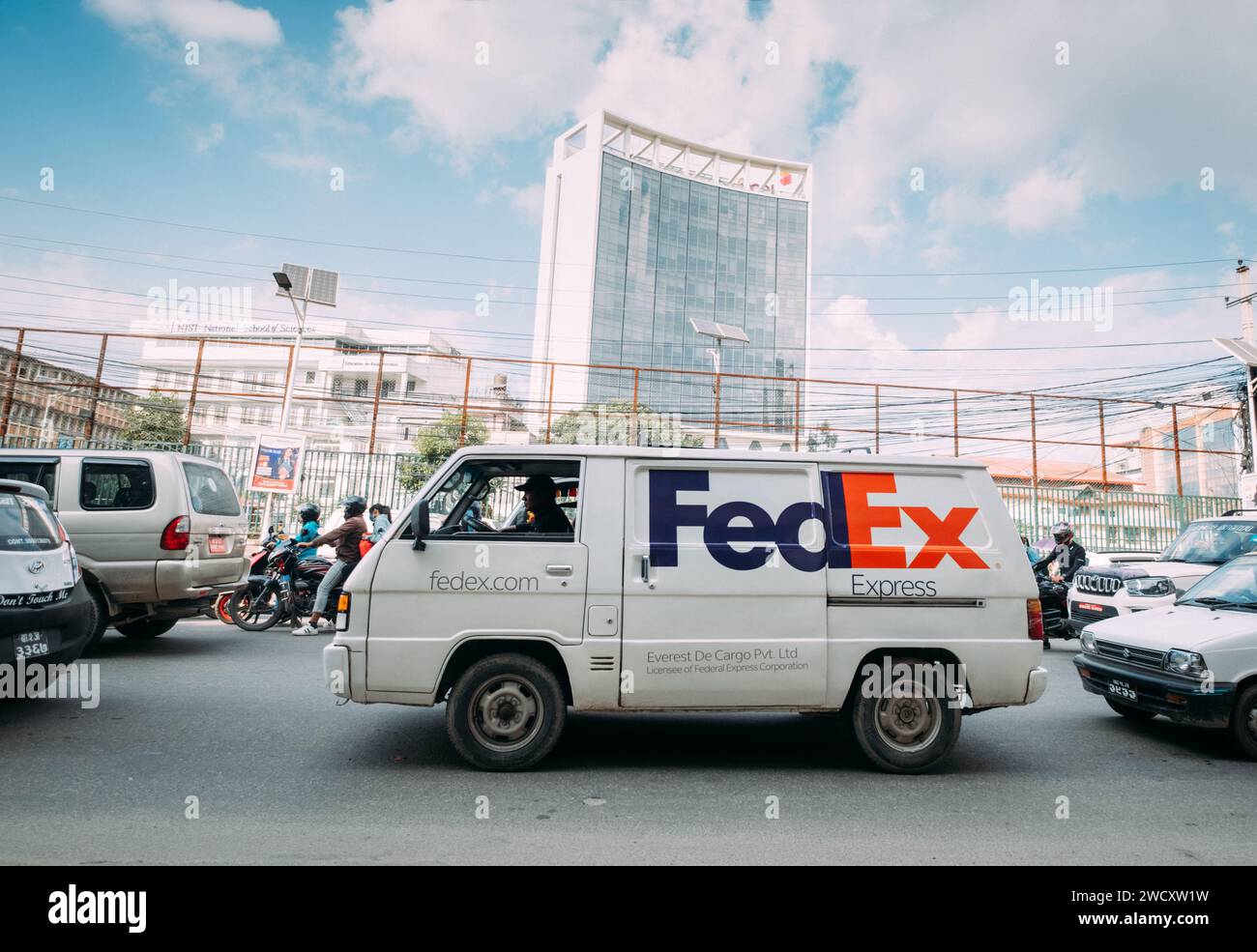 Katmandou, Népal - 5 octobre 2023 : van FedEx blanc avec un logo d'entreprise à Katmandou Urban Buzz, moto scooters dans les rues népalaises poussiéreuses à Katmandou, Banque D'Images