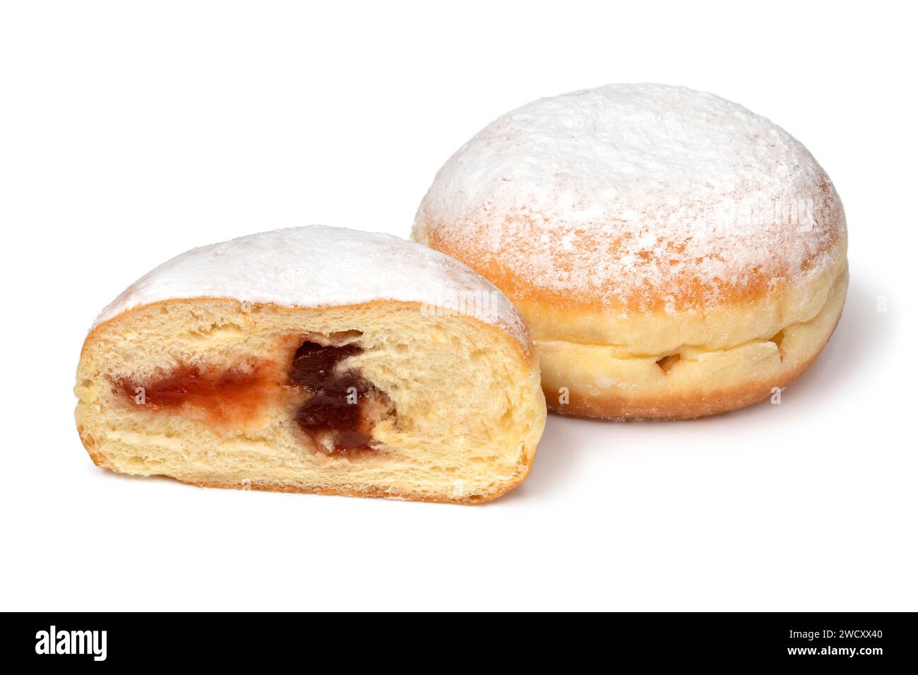 Beignets Berliner frais cuits entiers et coupés en deux recouverts de sucre de près isolés sur fond blanc Banque D'Images