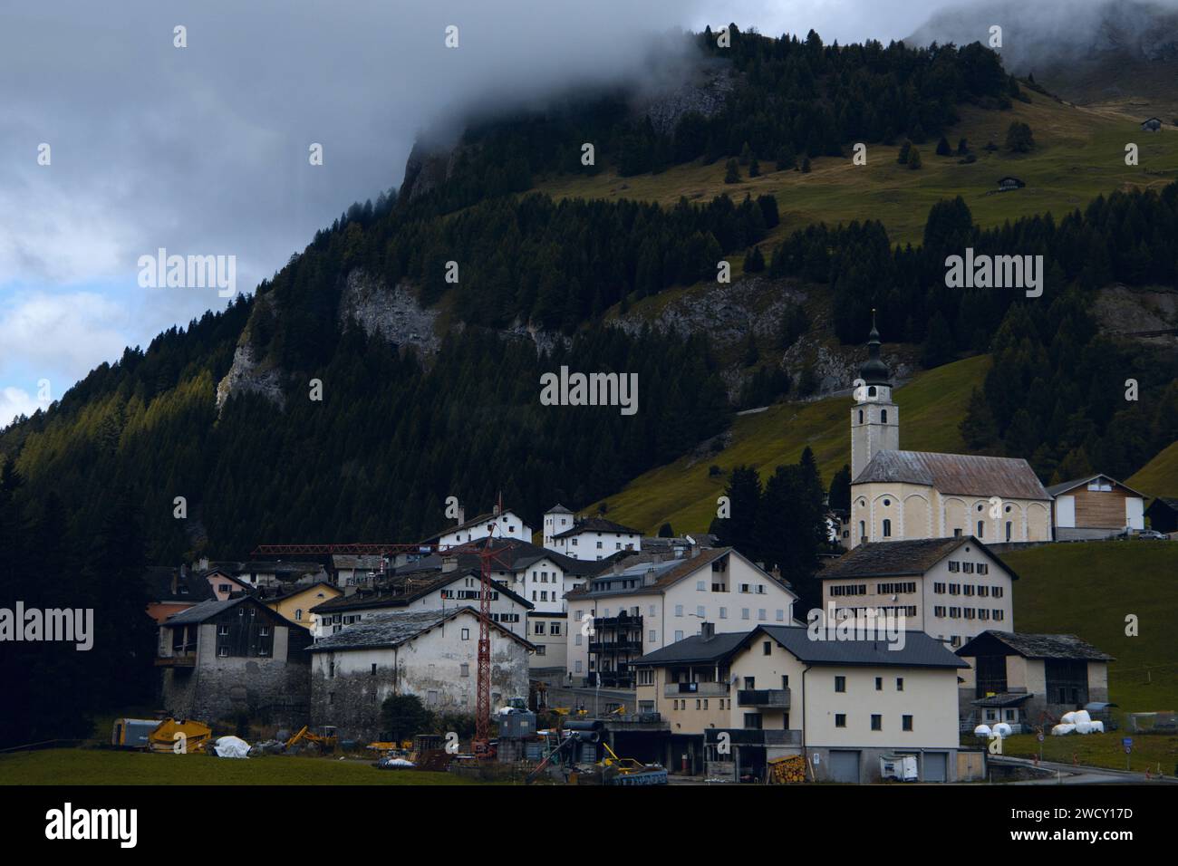 Sanctuaire de montagne : un village contre la colline boisée, couvert dans la brume Banque D'Images