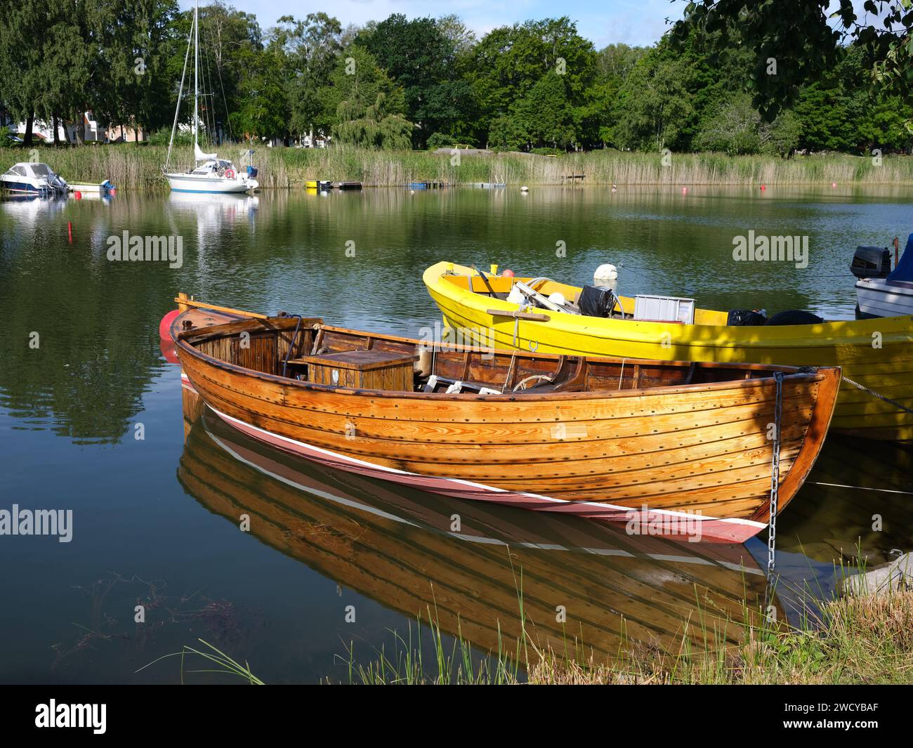 Bois verni petit bateau posé dans l'eau le jour de l'été. Banque D'Images