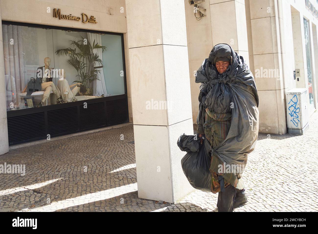 Une personne sans abri devant une boutique de luxe Banque D'Images