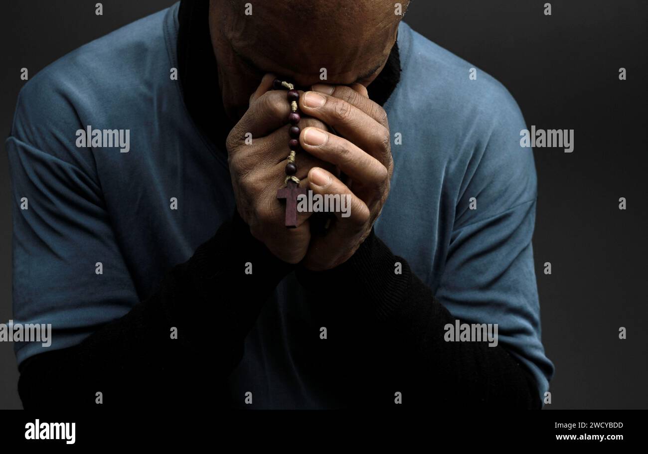 Homme noir priant à Dieu avec les mains ensemble homme des Caraïbes priant avec les gens image stock photo stock Banque D'Images