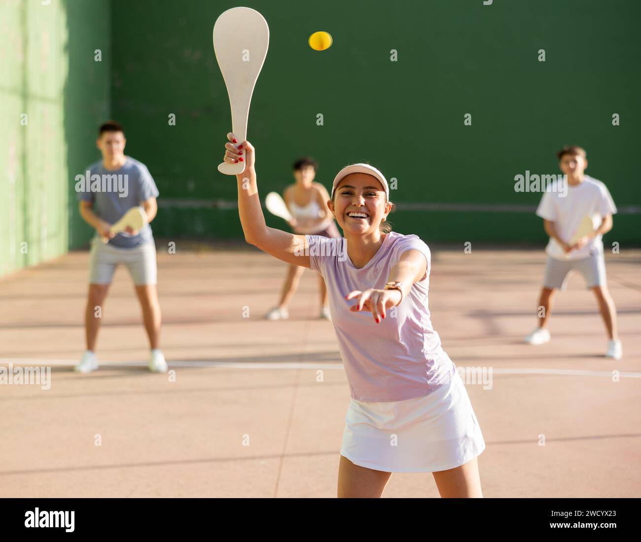 Portrait d'une fille sportive jouant paleta fronton sur un terrain extérieur, prêt à frapper le ballon. Concept de mode de vie sain et actif Banque D'Images