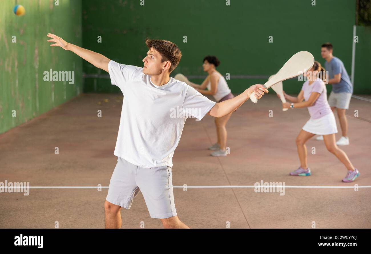 Jeune homme servant le ballon pendant le jeu de pelota basque en plein air Banque D'Images