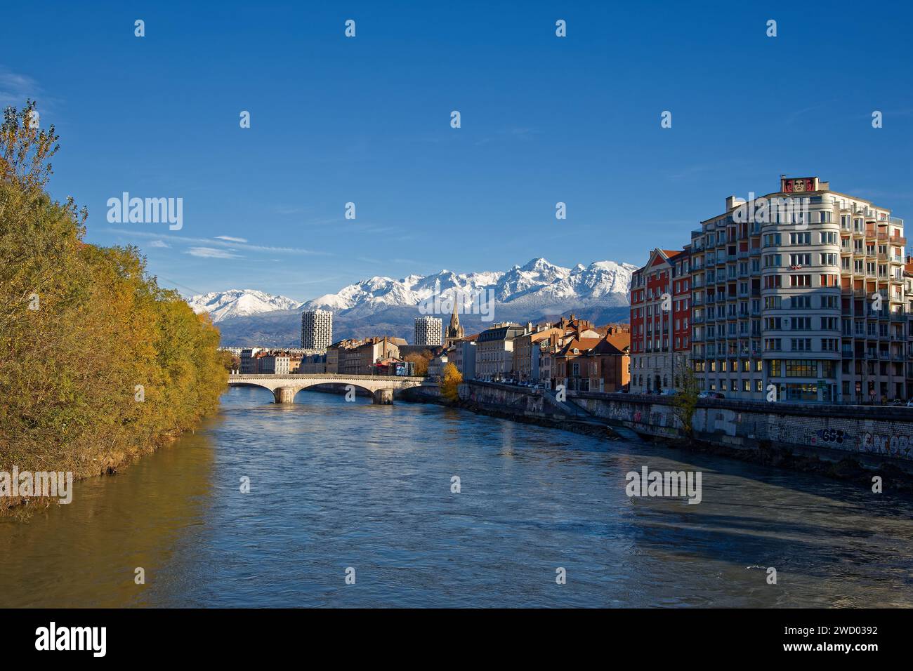 GRENOBLE, FRANCE, 29 novembre 2023 : fleuve Isère et centre-ville de Grenoble avec paysage de montagnes enneigées en arrière-plan Banque D'Images