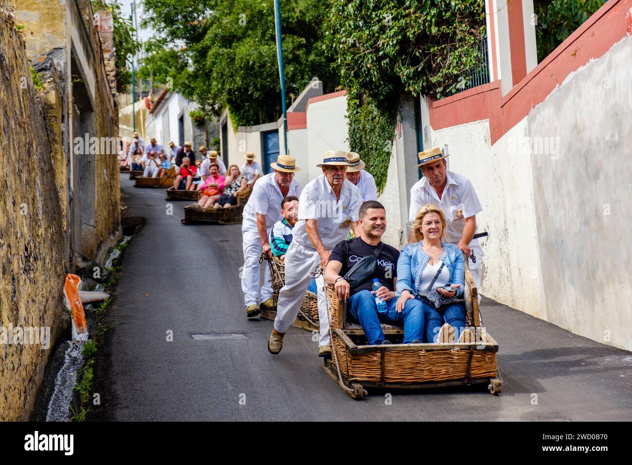 Touristes poussés en descente par carreiros, carros de cesto, paniers, Monte toboggan tour, paniers en osier montés sur patins, Funchal, Madère Banque D'Images