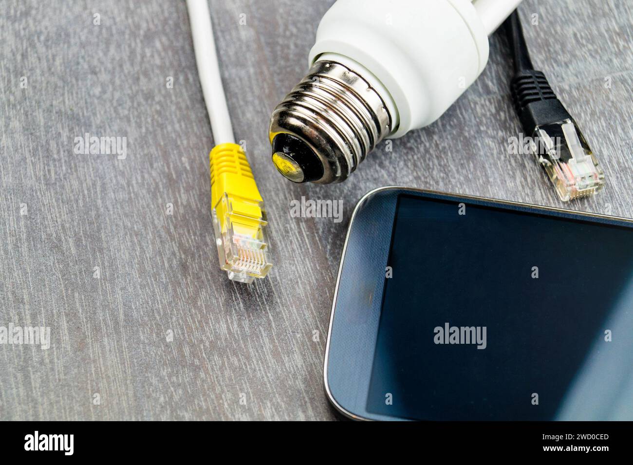 Lampe à économie d'énergie, téléphone intelligent et prise réseau, image symbolique pour la maison intelligente Banque D'Images