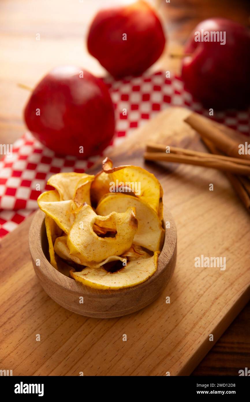 Croustilles de pommes maison, fines tranches de pomme déshydratées et cuites au four, saupoudrées de cannelle en poudre, recette facile pour une collation saine. Banque D'Images