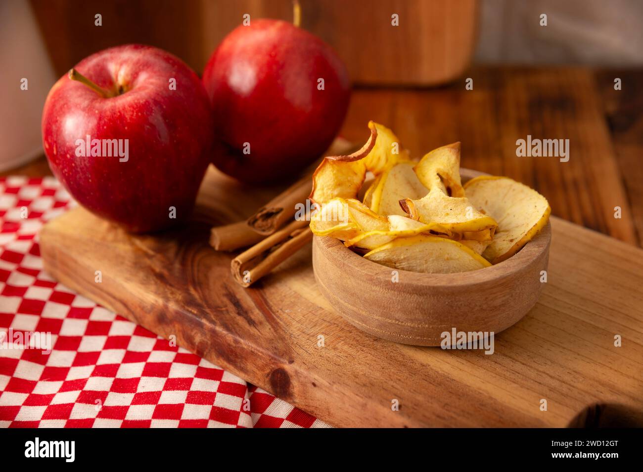 Croustilles de pommes maison, fines tranches de pomme déshydratées et cuites au four, saupoudrées de cannelle en poudre, recette facile pour une collation saine. Banque D'Images