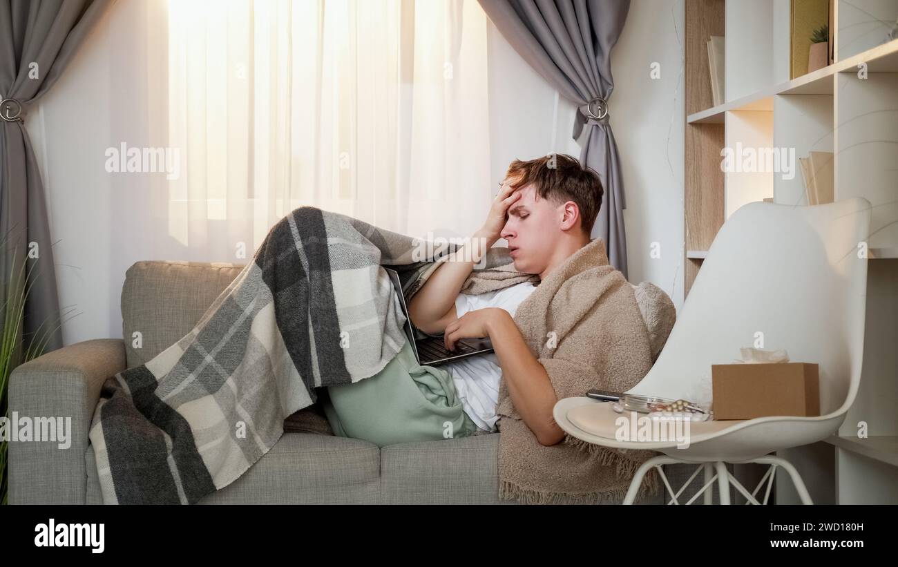Vidéo consultation homme mal de tête canapé portable à la maison Banque D'Images