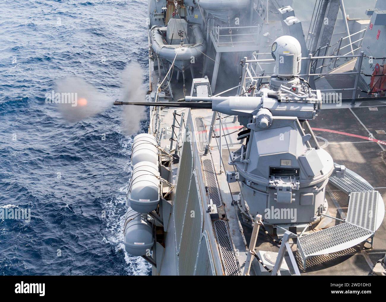 Le destroyer à missiles guidés USS Pinckney tire sa mitrailleuse Mark 38 25 mm. Banque D'Images