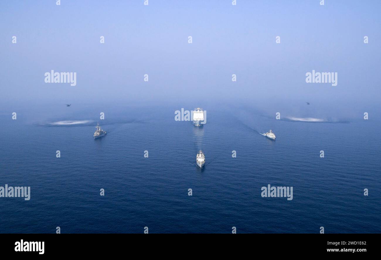 USS Sentry, HMS Bangor, HMS Ledbury et Cardigan Bay vapeur en formation avec deux hélicoptères MH-53 Sea Dragon. Banque D'Images