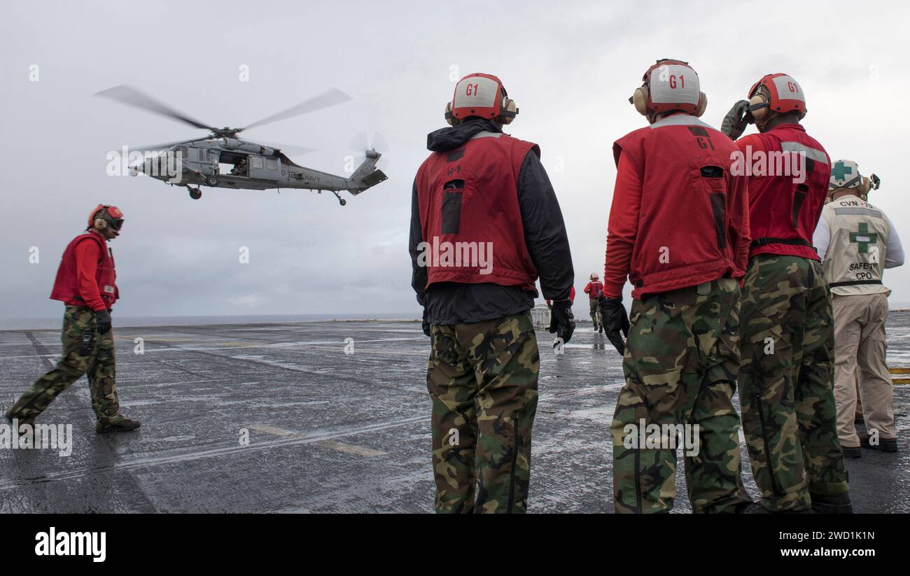 Hélicoptère effectuant un réapprovisionnement vertical en mer avec navire de la marine américaine. Banque D'Images