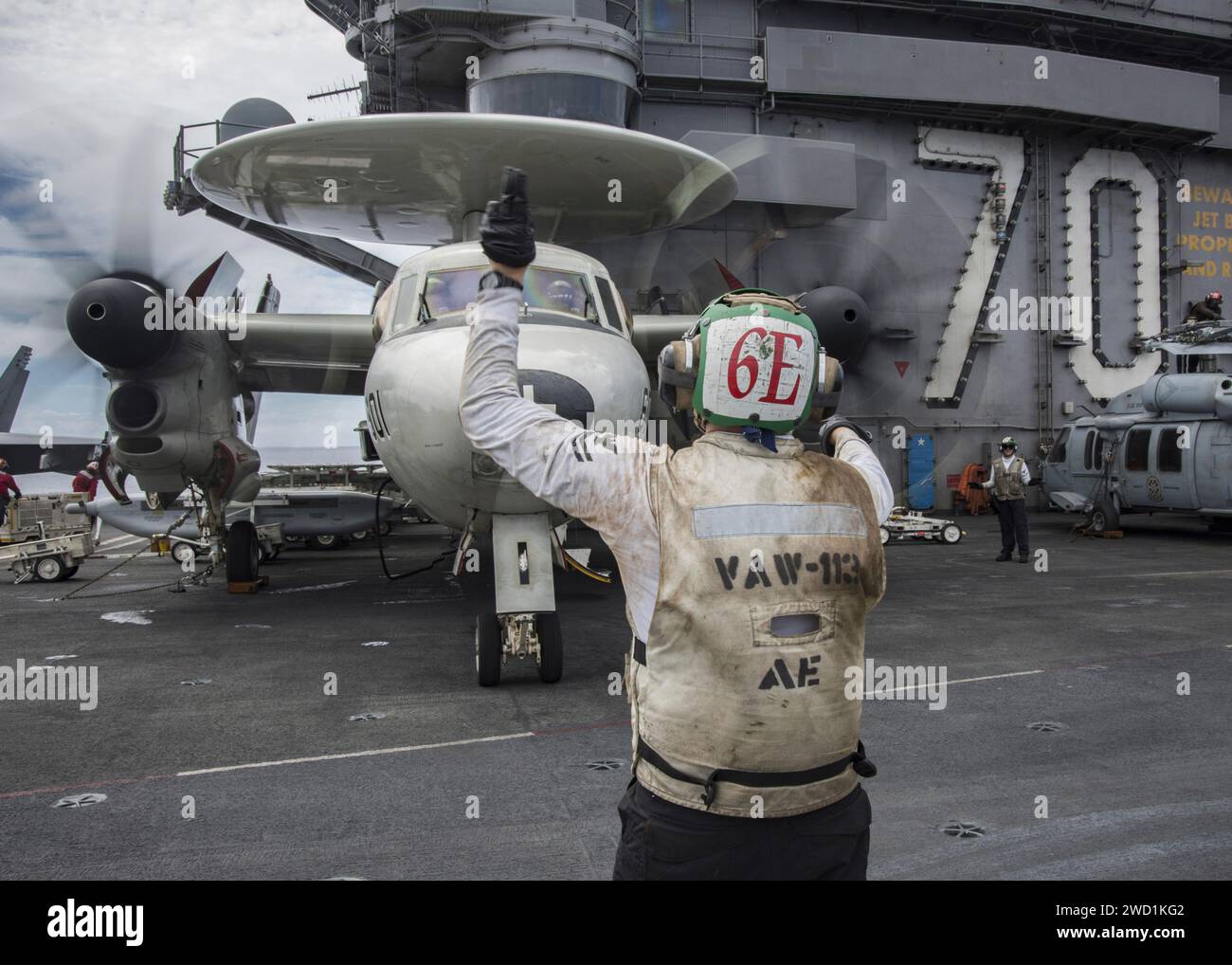 Les marins se préparent à déplacer un avion d'alerte précoce et de contrôle E-2C Hawkeye à bord de l'USS Carl Vinson. Banque D'Images