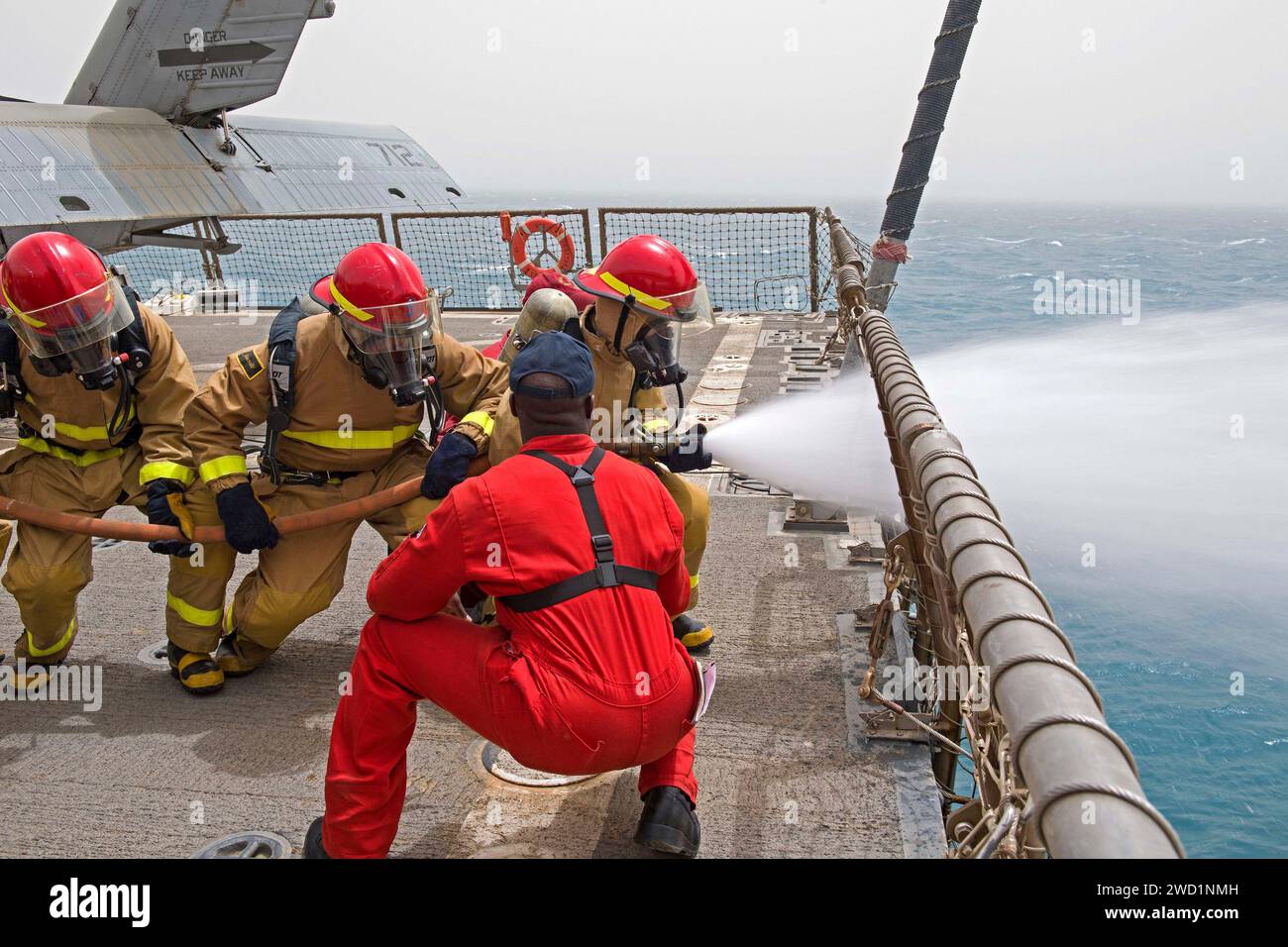 Damage Controlman Fireman effectue un exercice de manipulation de tuyaux d'incendie avec des marins de la marine égyptienne à bord de l'USS Truxtun. Banque D'Images